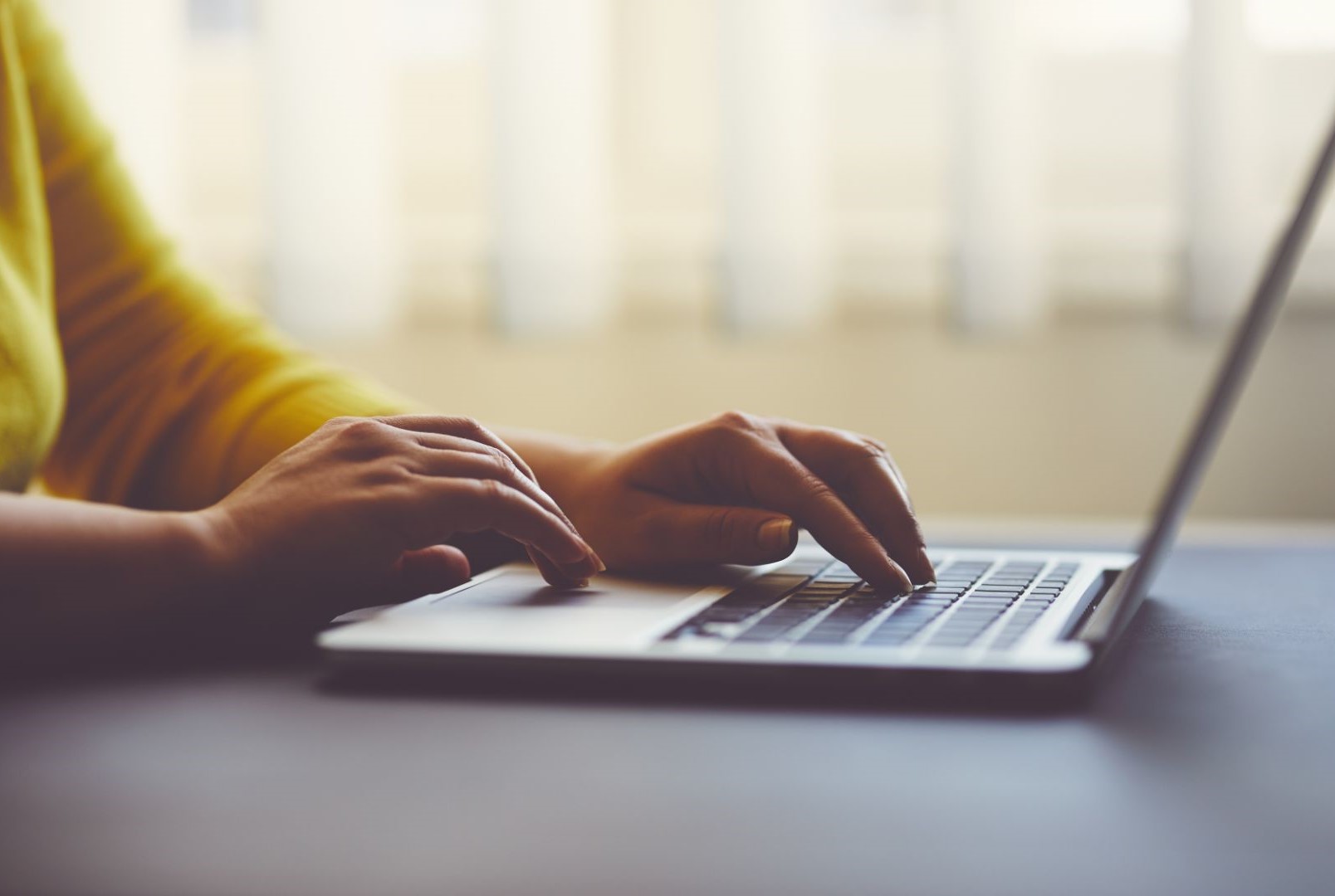 Woman at table working on laptop