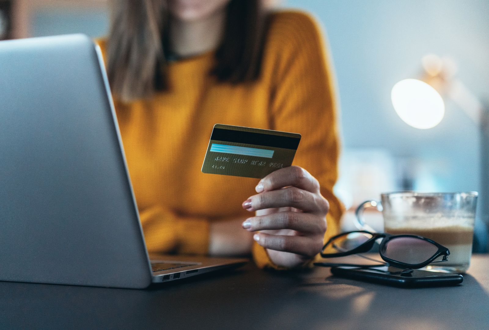 Woman on her laptop holding a credit card