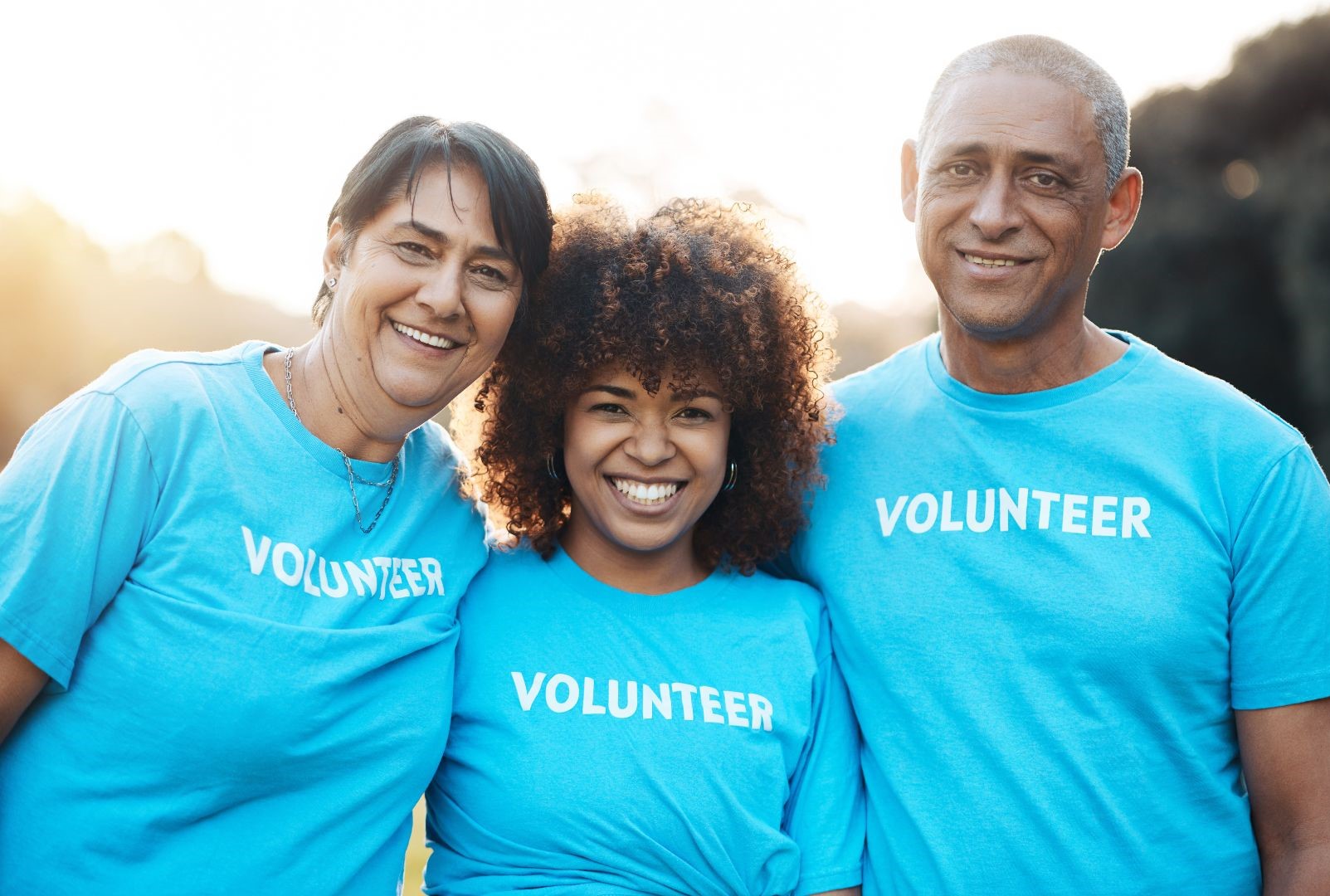 Three people wearing volunteer shirts