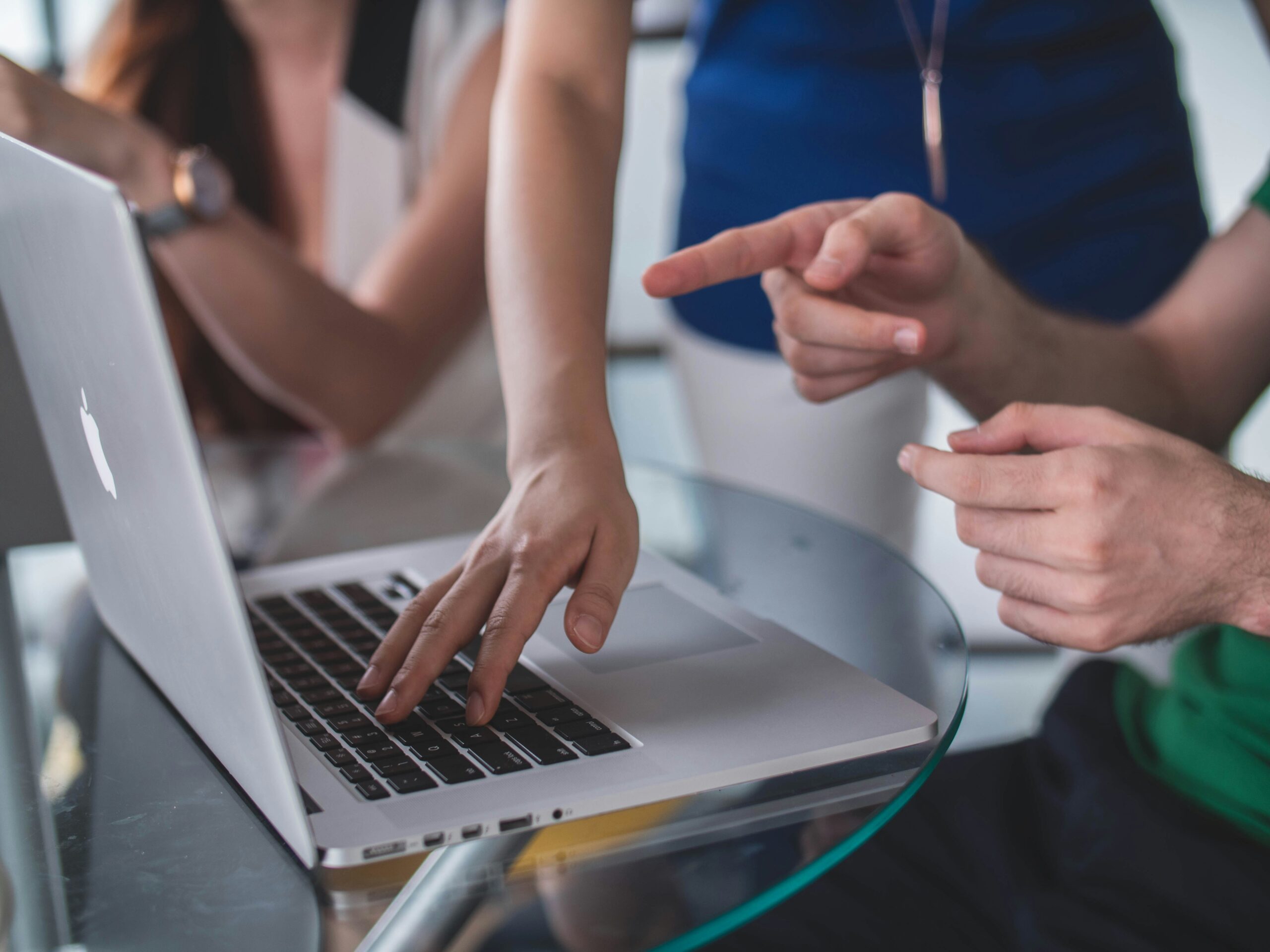 Person touching and pointing at MacBook